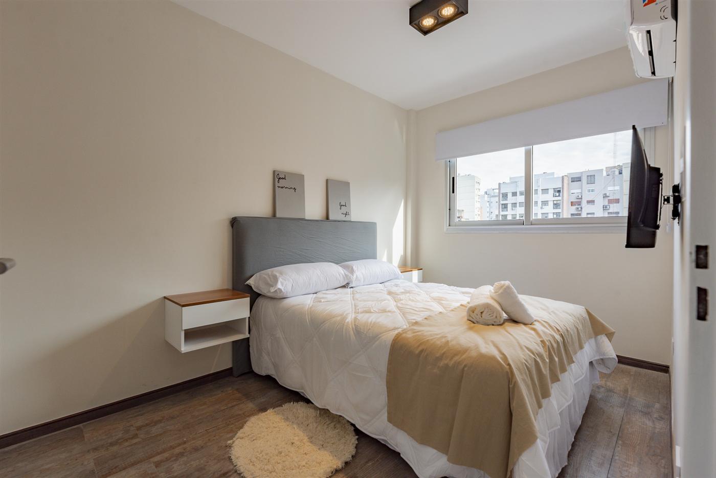 Dormitorio con cama queen y TV
